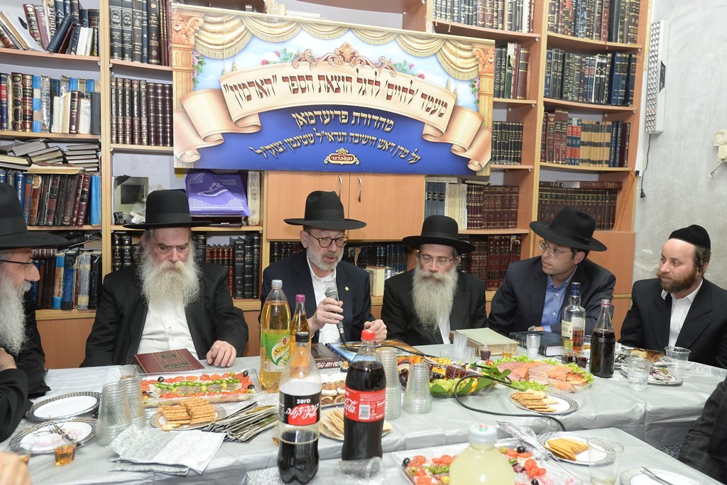 1. הנגיד הרר הערשי פרעידמאן נואם באירוע לצידו בני מרן הרב שטינמן זצ''ל.jpeg
