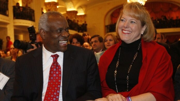 Supreme Court Justice Clarence Thomas, left, sits with his wife Virginia Lamp Thomas.