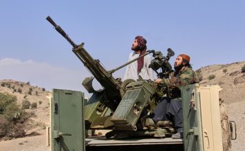 Taliban fighters look up while manning an armed pickup truck at the Afghan side of the Ghulam Khan crossing with Pakistan in Khost province, Afghanistan, Friday, Feb. 27, 2026. (AP Photo/Saifullah Zahir)