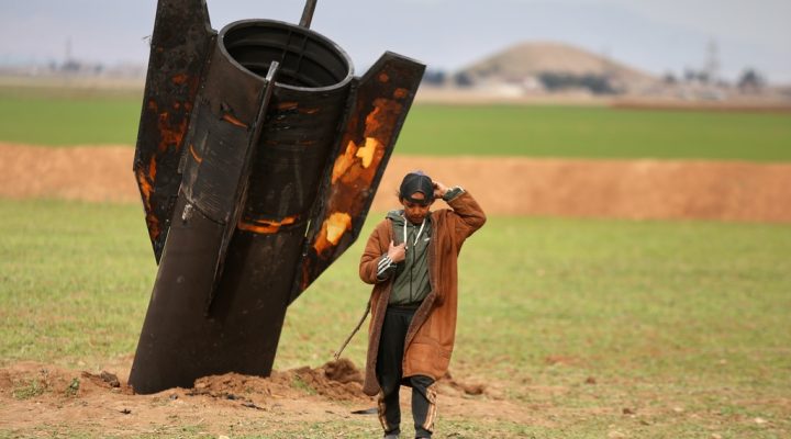 A shepherd boy walks away from an unexploded Iranian projectile that landed in an open field in the outskirts of Qamishli, eastern Syria, Wednesday, March 4, 2026.(AP Photo/Baderkhan Ahmad)