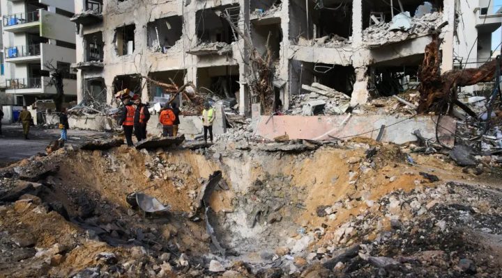 Rescue workers and military personnel survey the scene of a direct hit a day after an Iranian missile struck in Tel Aviv, Israel, Sunday, March 1, 2026. (AP Photo/Oded Balilty)